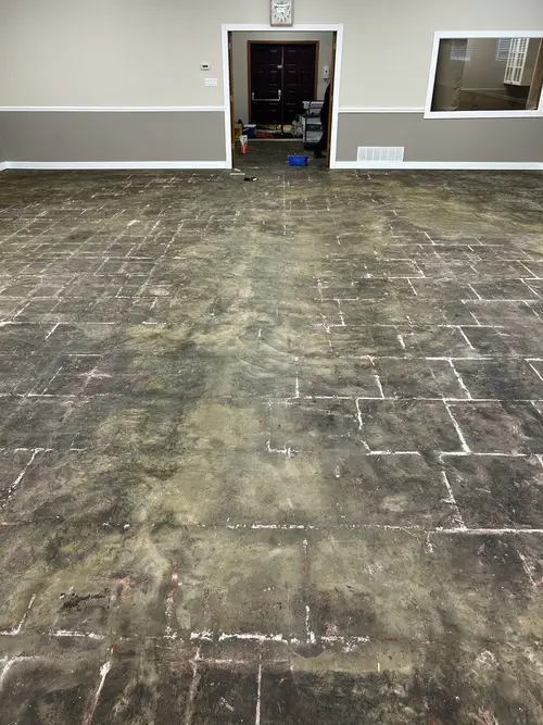 Bare floor with old adhesive before professional carpet tile installation in London, Ontario