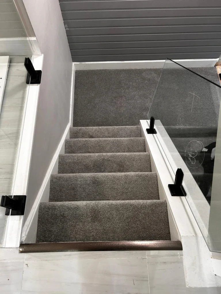Close-up of medium pile grey plush carpet installed on basement stairs in London Ontario residential home
