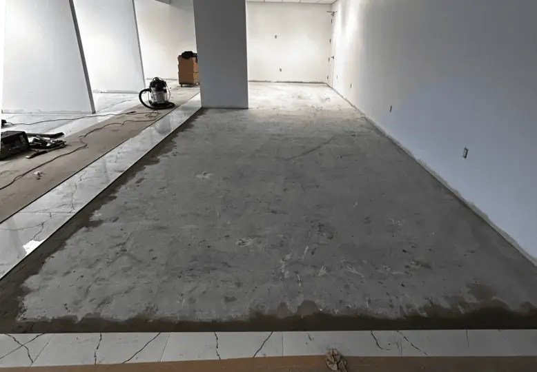 large office lounge with bare concrete floor in Downtown London Ontario before commercial carpet tile installation