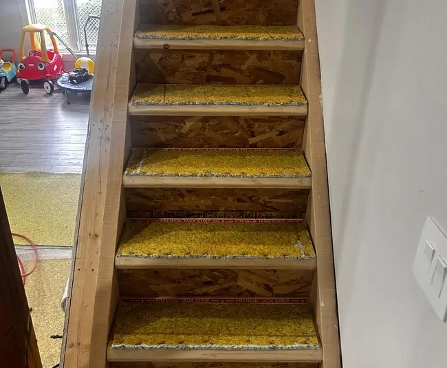 Staircase with new underpad in St. Thomas, Ontario before thick grey carpet installation