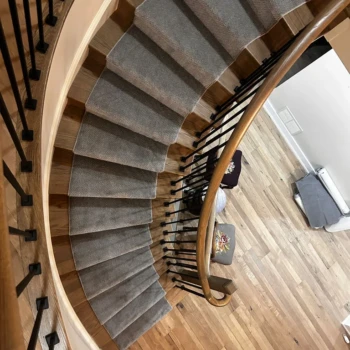 Grey carpet runner installed on hardwood stairs โ durable and stylish stair runner in London Ontario home
