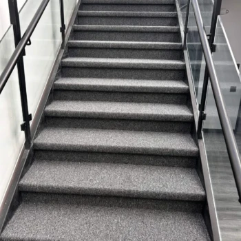 Close-up angle of Uplink commercial carpet installed on concrete stairs in London Ontario, durable and slip-resistant floor.